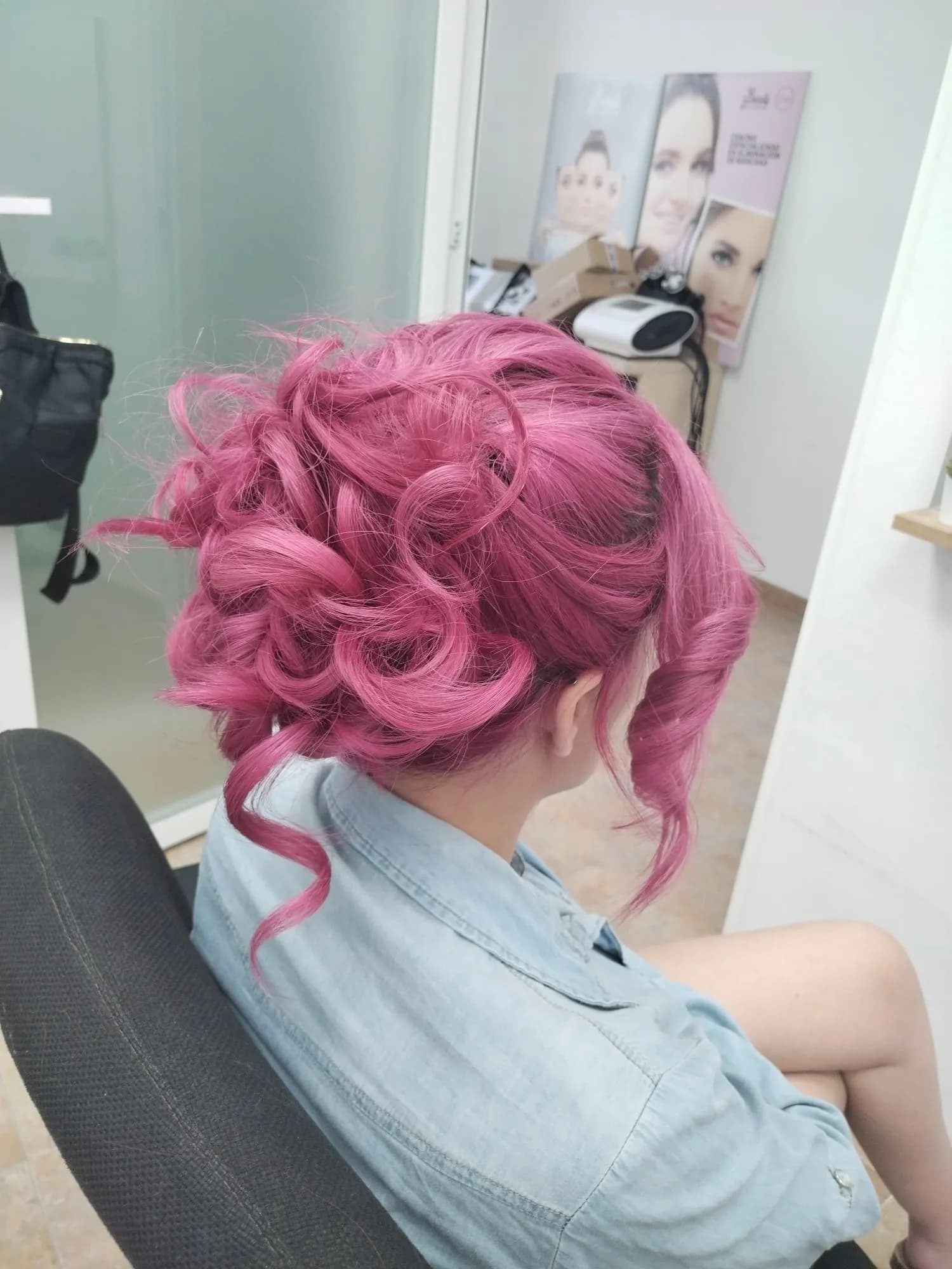 Recogido de peluquería en tono rosa con rizos definidos