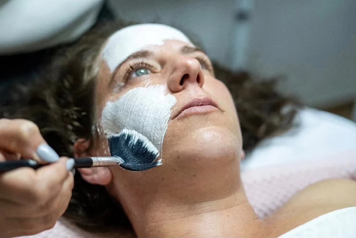 Clienta recibiendo un tratamiento facial, un momento presente de cuidado