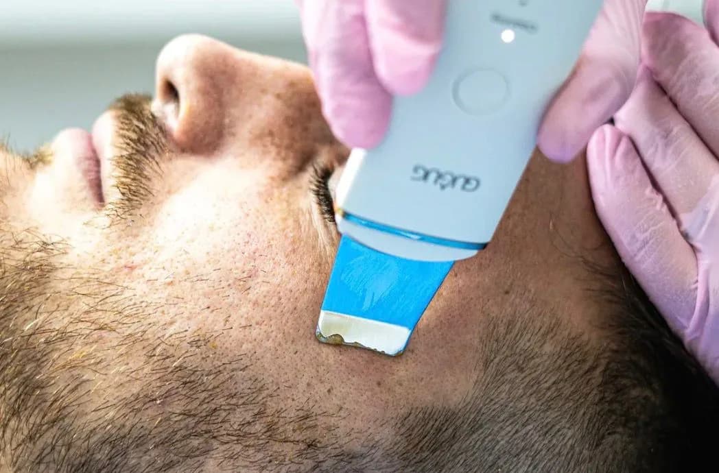 Especialista trabajando el rostro de una clienta con precisión durante una limpieza facial